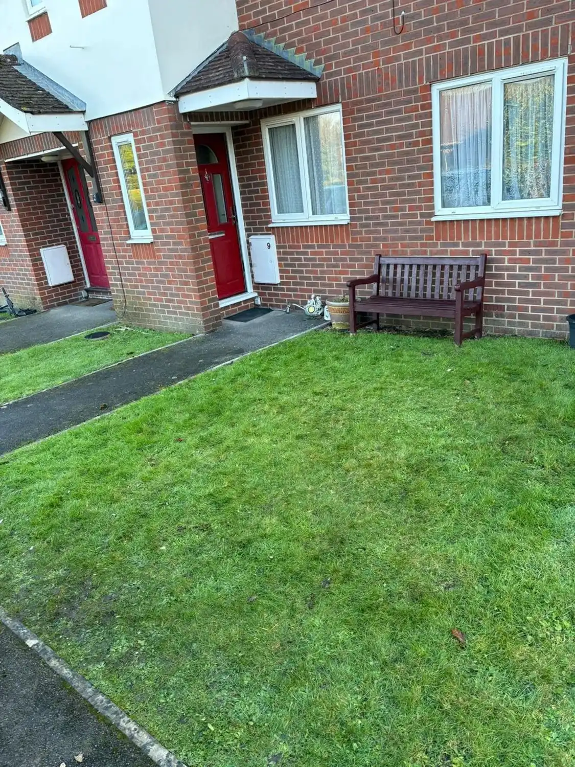 A bench sitting in front of a brick building.