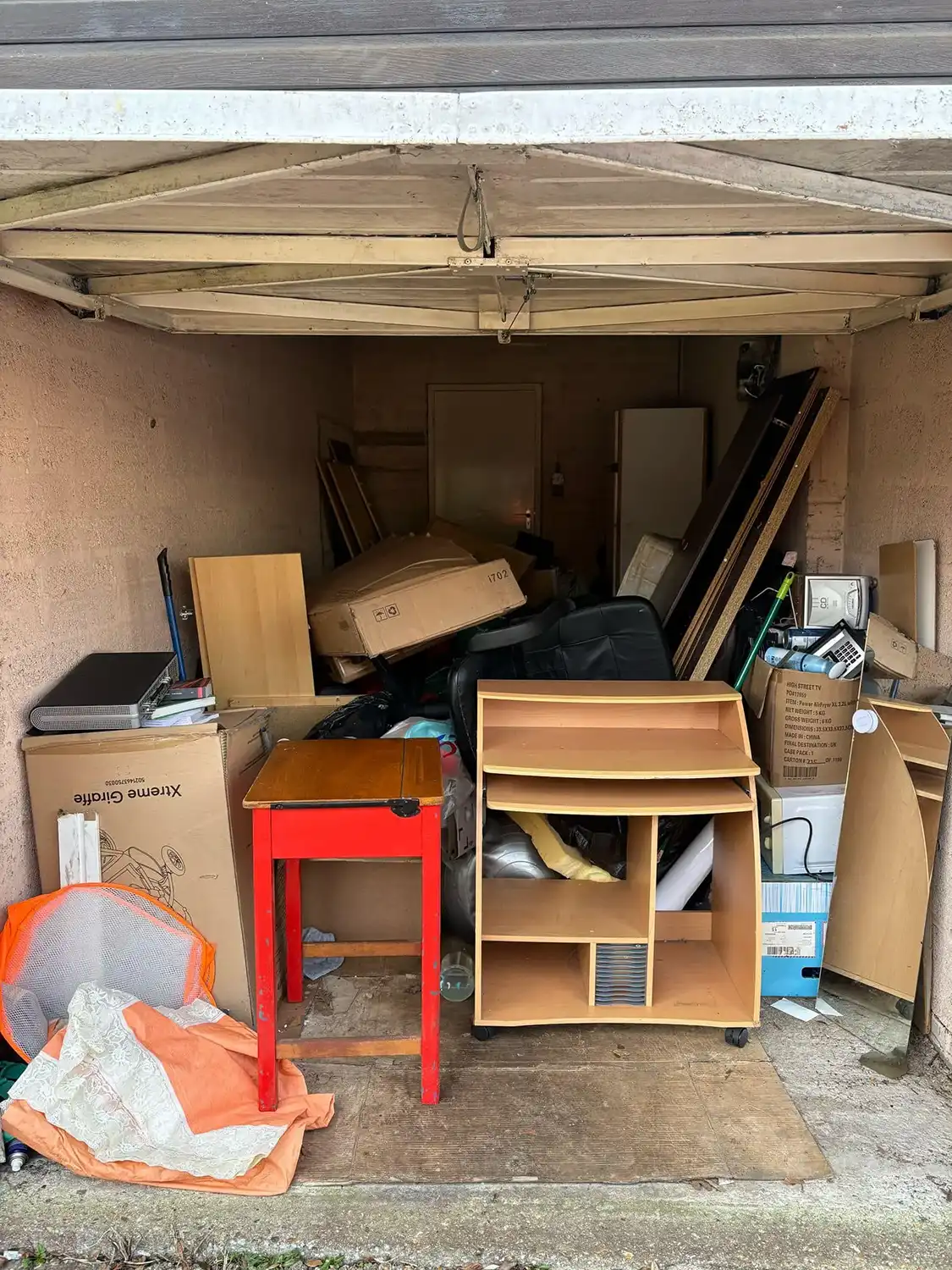 A garage filled with lots of boxes and furniture.