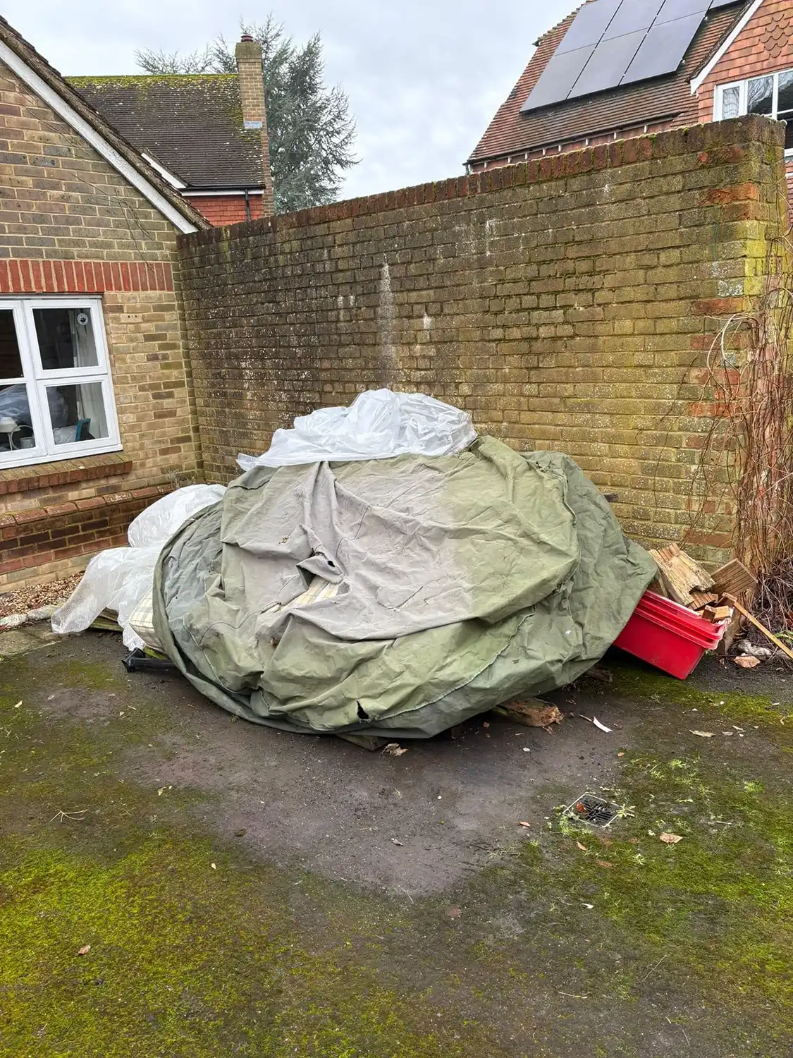 A pile of garbage sitting in front of a brick building.