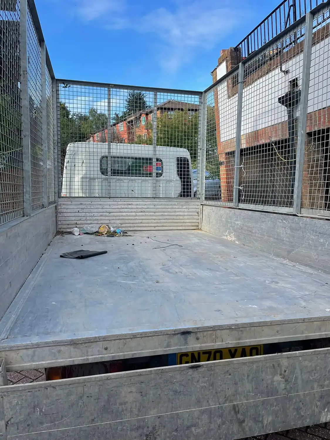 A lorry with a flat bed is parked in a road.