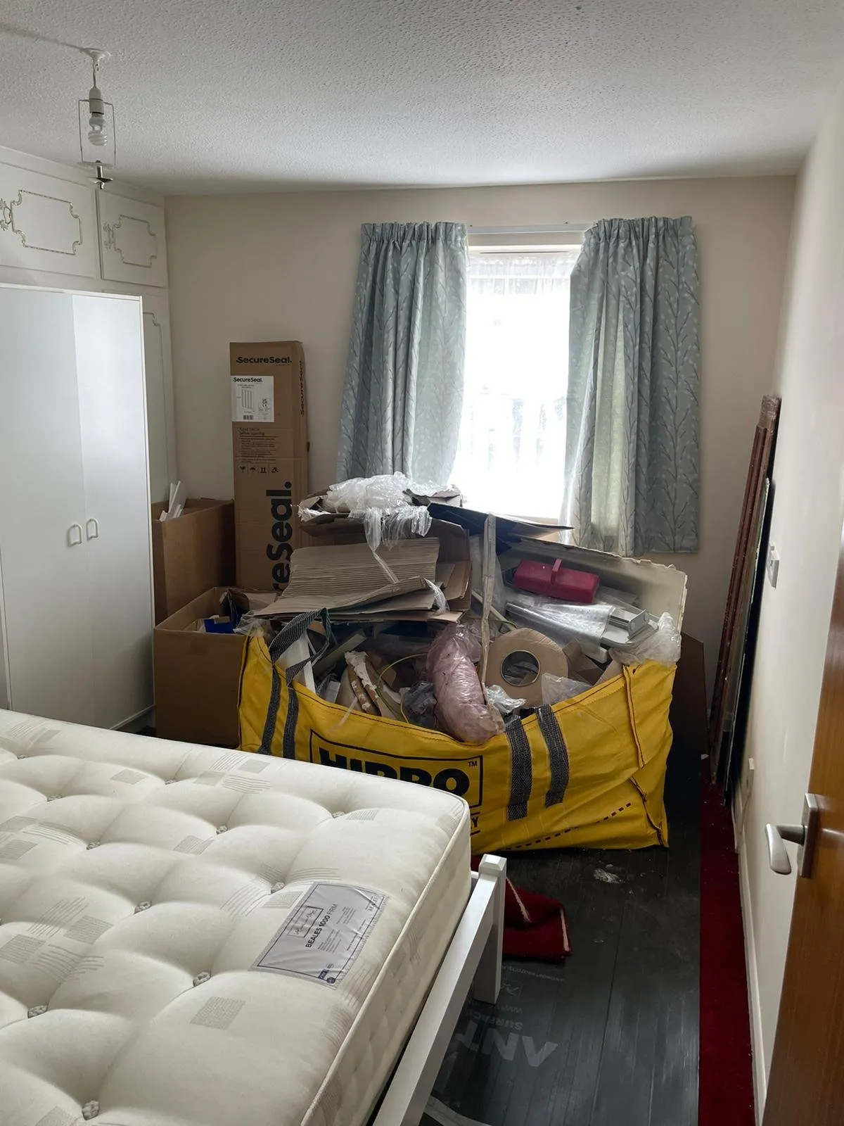A room filled with boxes and a mattress.